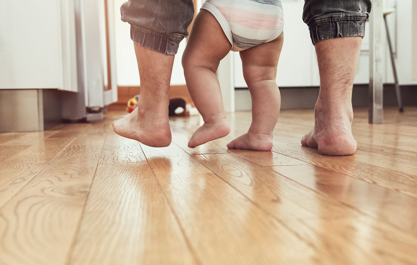 Parkettboden, Holzboden oder Massivholzboden im Wohnzimmer für Worms Füße von Papa und seinem Kind - laufend auf Parkettboden